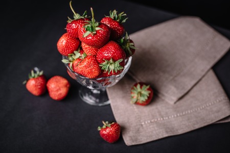 Ripe juicy strawberries in a glass on a dark backgroundの写真素材