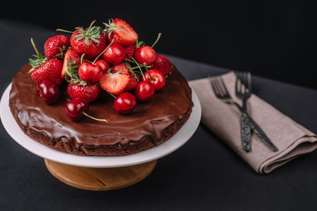 Tuscan chocolate cake with strawberries and cherries on dark backgroundの写真素材
