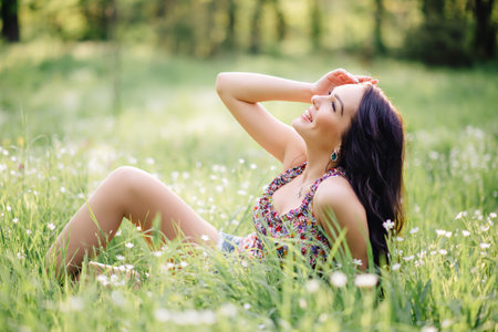 sunny summer day, a beautiful young girl lying on the grassの写真素材