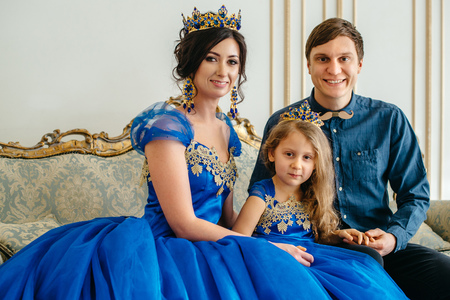 happy young family consisting of mother, father and little daughter in royal attireの写真素材