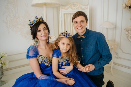 happy young family consisting of mother, father and little daughter in royal attireの写真素材