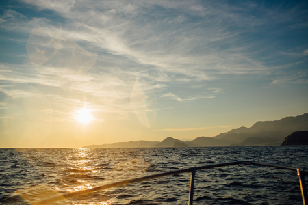 Coast of Montenegro at sunset, view from the sea, silhouettes of mountainsの写真素材