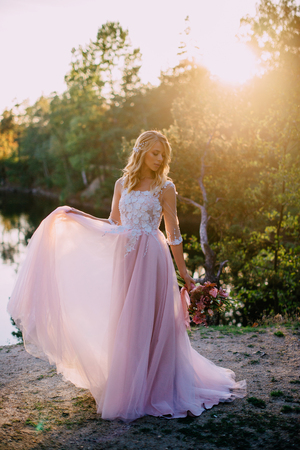 portrait of a young beautiful bride in the sun on a nature backgroundの写真素材