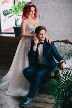 portrait of stylish newlyweds sitting in a vintage chairの写真素材