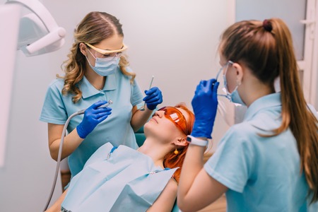 young red-haired woman at reception with dentistの写真素材