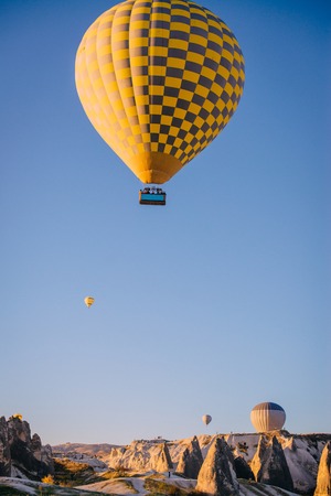balloon in sky over mountains in Goreme National Parkの写真素材