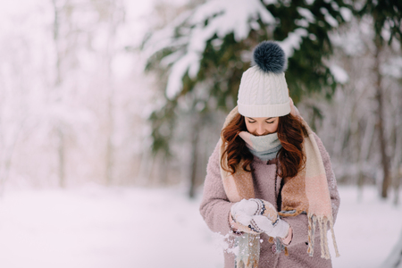 young woman making snowball hands in parkの写真素材