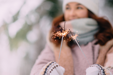 burning sparklers in womans hands, selective focusの写真素材