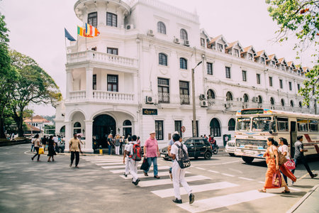 KANDI, SRI LANKA - FEBRUARY 2, 2018: pedestrians cross road near historical building of Queens hotel