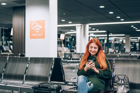 Woman uses free internet in airport terminalの写真素材
