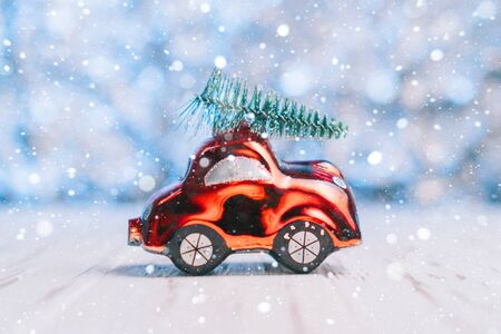 Close-up of a small toy car carries a xmas tree on the roof, concept Christmas and New Yearの写真素材