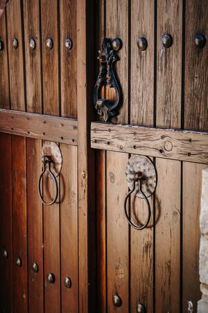 Old brown wooden gate with rings, closeup.の写真素材