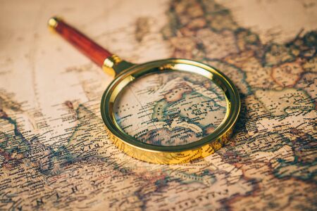 Magnifying glass on a vintage world map. Close up.の写真素材