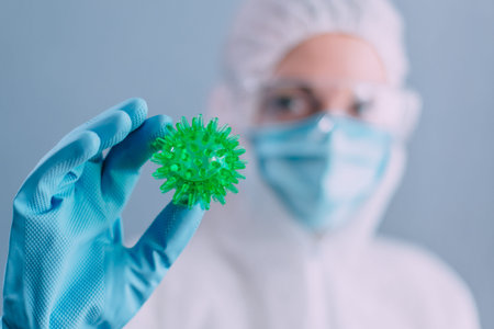 Doctor virologist in a protective suit examines the coronavirus. Close up.