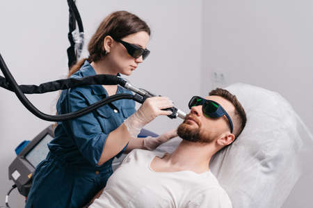 Laser depilation of beard contour. The depilation master treats the neck of a man with a laser.の写真素材
