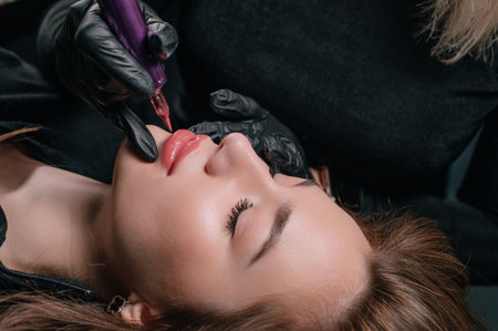 Permanent lip makeup. The cosmetologist makes the procedure of permanent makeup to the client in the salon.の写真素材
