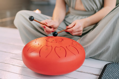 Young woman with sticks playing glucophone at home, close up.