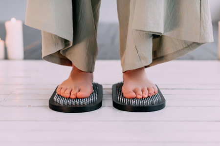 Feet standing on nails. Close-up of a leg.の写真素材