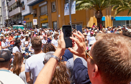Man taking photos of the procession using mobile phone.
