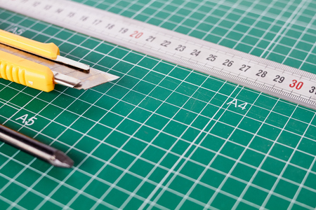 cutter, ruller and pencil on a green cutting matの写真素材