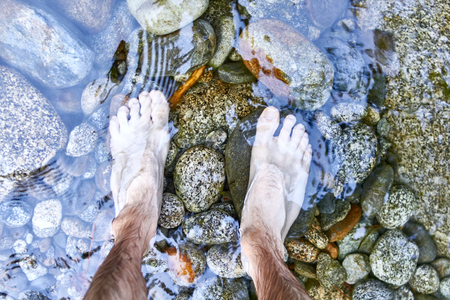 Men foot on a riverの写真素材