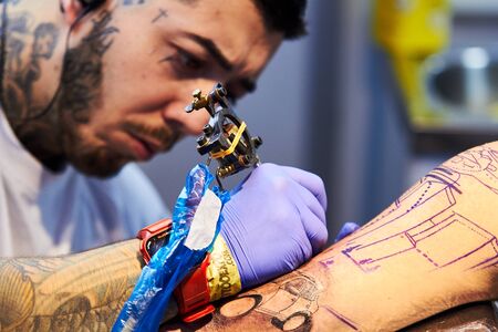 ALICANTE TATTOO FAIR CIRCA 2018 concentrated tattoo artist workingのeditorial素材