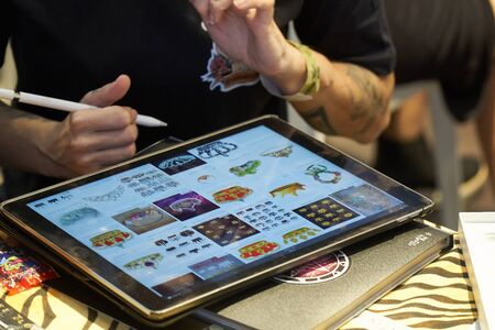 ALICANTE TATTOO FAIR CIRCA 2018 tattoo artist drawing a sketch on a tabletのeditorial素材