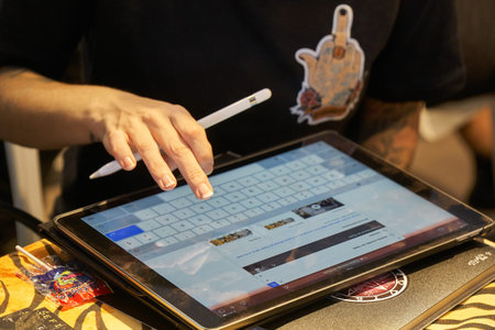 ALICANTE TATTOO FAIR CIRCA 2018 tattoo artist drawing a sketch on a tablet