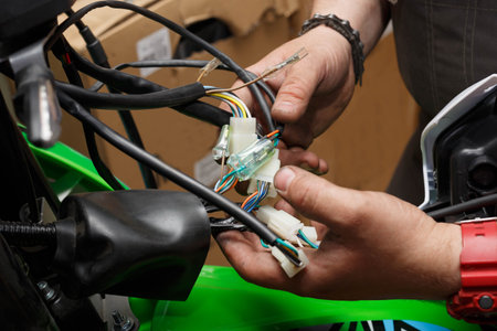 The process of connecting electrical wires in the assembly of a new motorcycle in operation.の写真素材