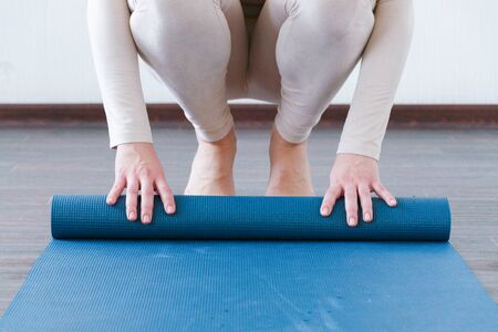 Beautiful girl getting ready for yoga indoors in daylight. Active lifestyle.の写真素材