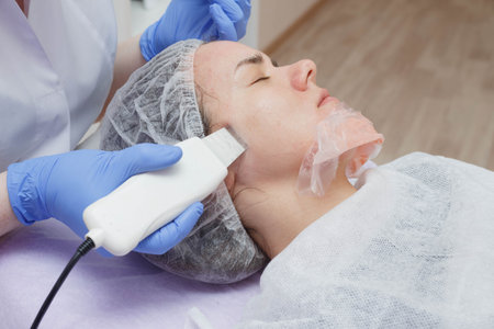 The girl is provided with an ultrasound skin cleaning service in the beauty salon.