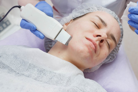woman getting ultrasound skin cleaning at beauty salon.
