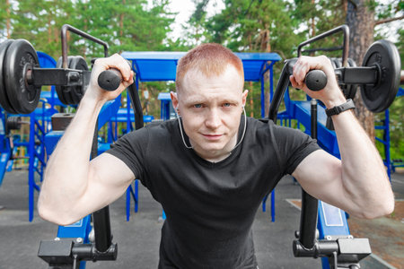 Sport man doing abs crunches exercise, fitness workout at street. Man Training with Weights Outdoors...