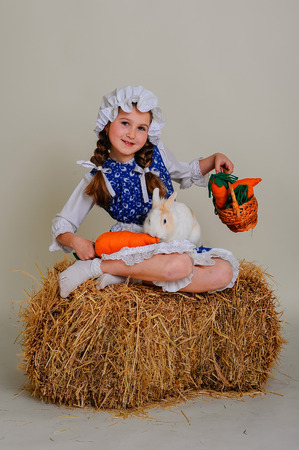 girl in the hay feeding the Easter Bunny carrotsの写真素材