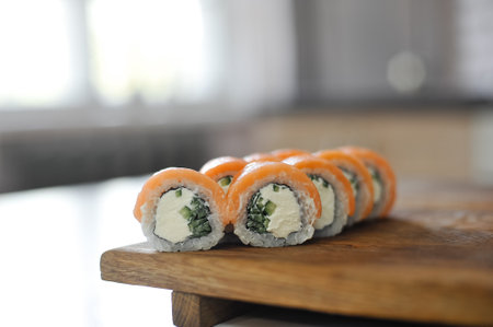 sushi roll with salmon, avocado, cucumber and wasabi on wooden boardの写真素材