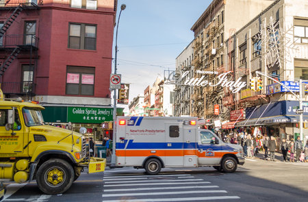 Ordinary Day in Little Italy and Chinatown. Busy Road and Pavement. An Ambulance is passing by the Road and a Yellow Truck Follows Next. Manhattan, New York City, USAのeditorial素材