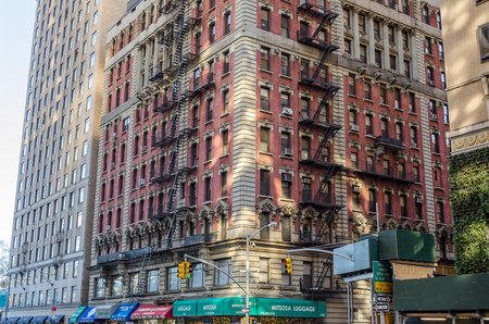 Typical Manhattan Building With Fire Escape Ladders and Many Stores on the Ground Floor. New York City, USAのeditorial素材
