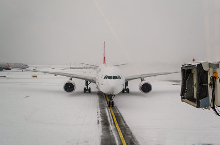 Airplane Getting Ready for Passengers to Î’oard. JFK Airport on a Snowy Day. Pilot and Co-Pilot...