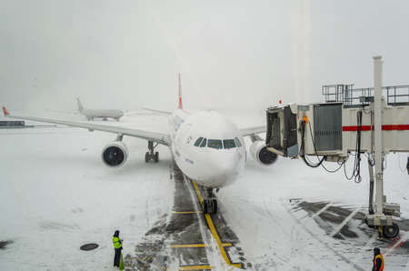Airplane Getting Ready for Passengers to Îoard. JFK Airport on a Snowy Day. Pilot and Co-Pilot at Cockpit are ready for the Flight. New York City, USAのeditorial素材