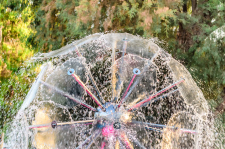 Close Up View of a Beautiful Round Fountain Bursting Water Droplets is a Pattern. Hidden Lights...