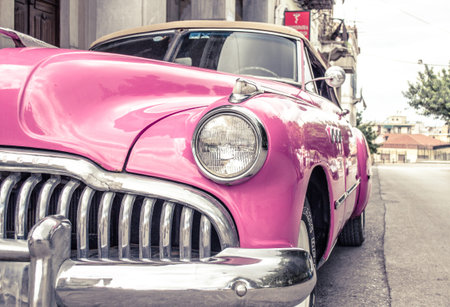 Patras, Achaia, Greece - Jun 7th 2015: Pink Vintage Antique Car. Super Convertible Sedan Parked Aside the Road in an Old Neighborhoodの写真素材