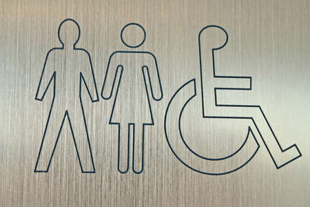 metal sign showing accessible washrooms for men and womenの写真素材