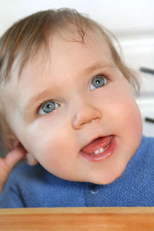 adorable baby smiling and showing two new teethの写真素材