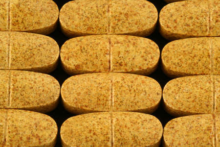 dietary supplement multi - vitamin pills lined in a regular pattern, showing nice organic textureの写真素材