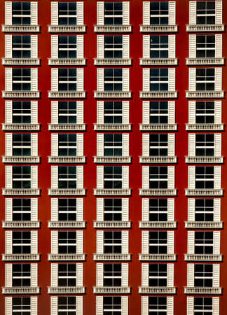 a part of a red building with a regular pattern of windowsの写真素材
