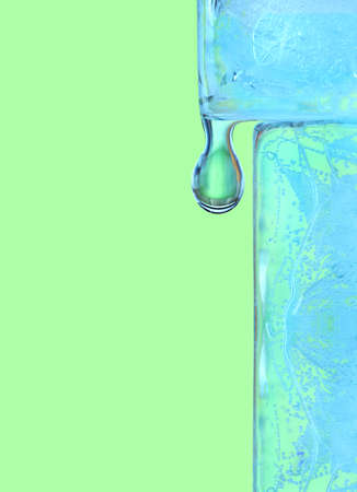 close up of a water drop on a corner of a melting ice cubeの写真素材