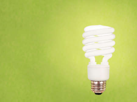 compact fluorescent energy saving environment friendly bulb on green backgroundの写真素材