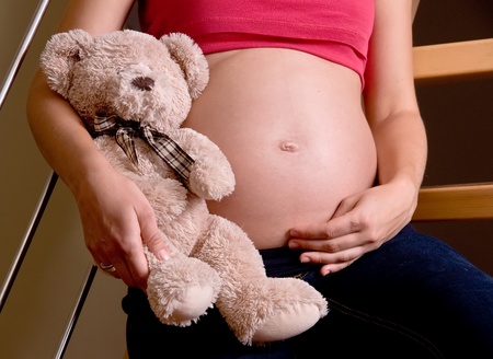 pregnant woman is holding teddy bear. pregnancy conceptの写真素材