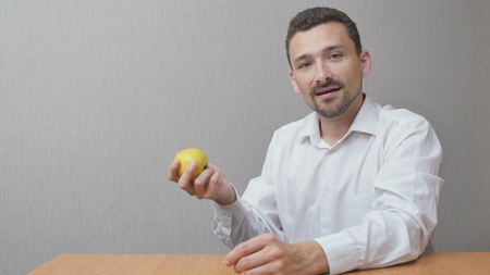 The man is eating a green apple. The person tosses the apple and bites it. healthy lifestyleの写真素材