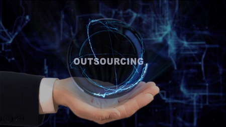 Painted hand shows concept hologram Outsourcing on his hand. Drawn man in business suit with future technology screen and modern cosmic backgroundの写真素材